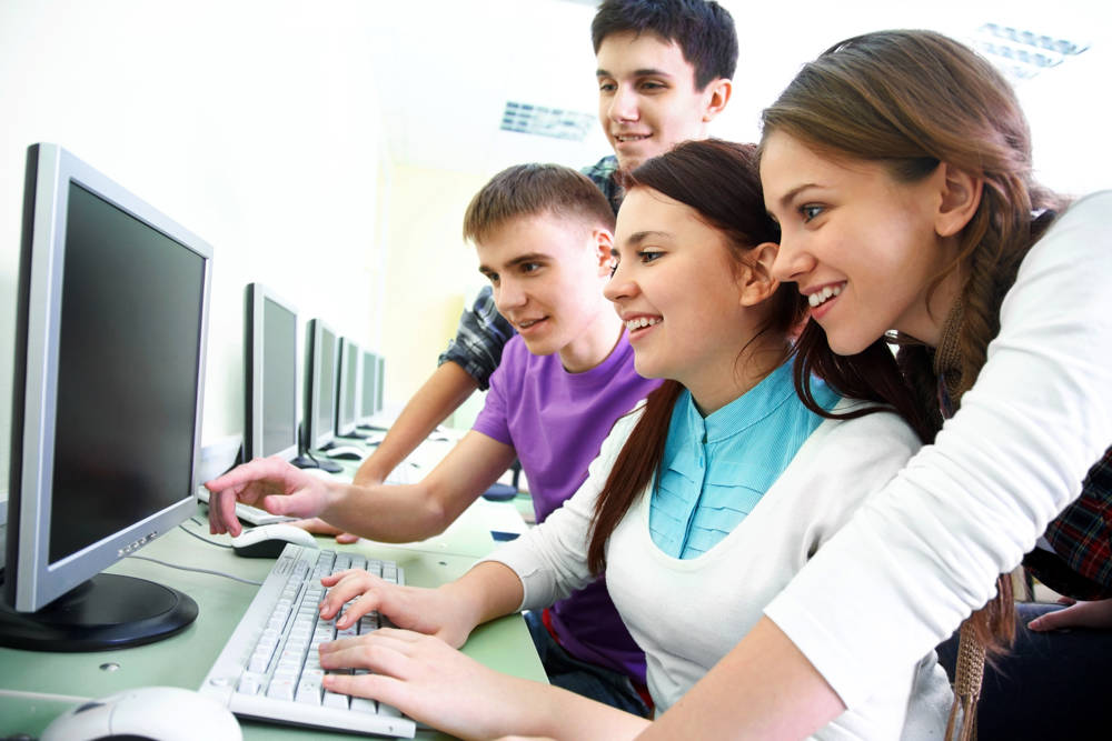 group of young students studying in the classroom with computer